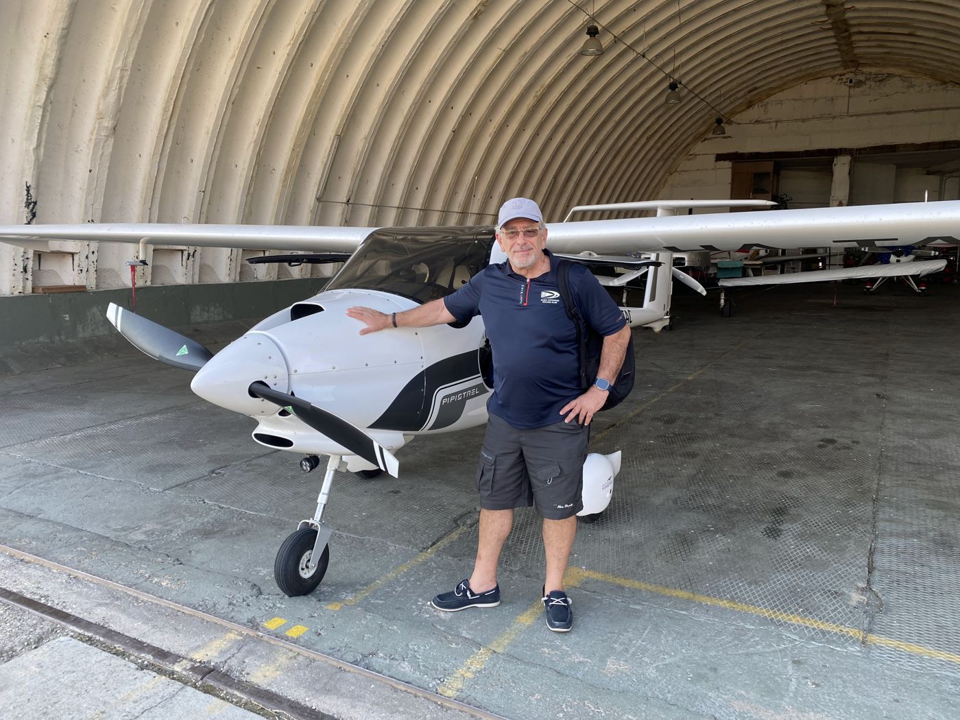 Bashar beside a Pipistrel aircraft at a hangar in Hungary